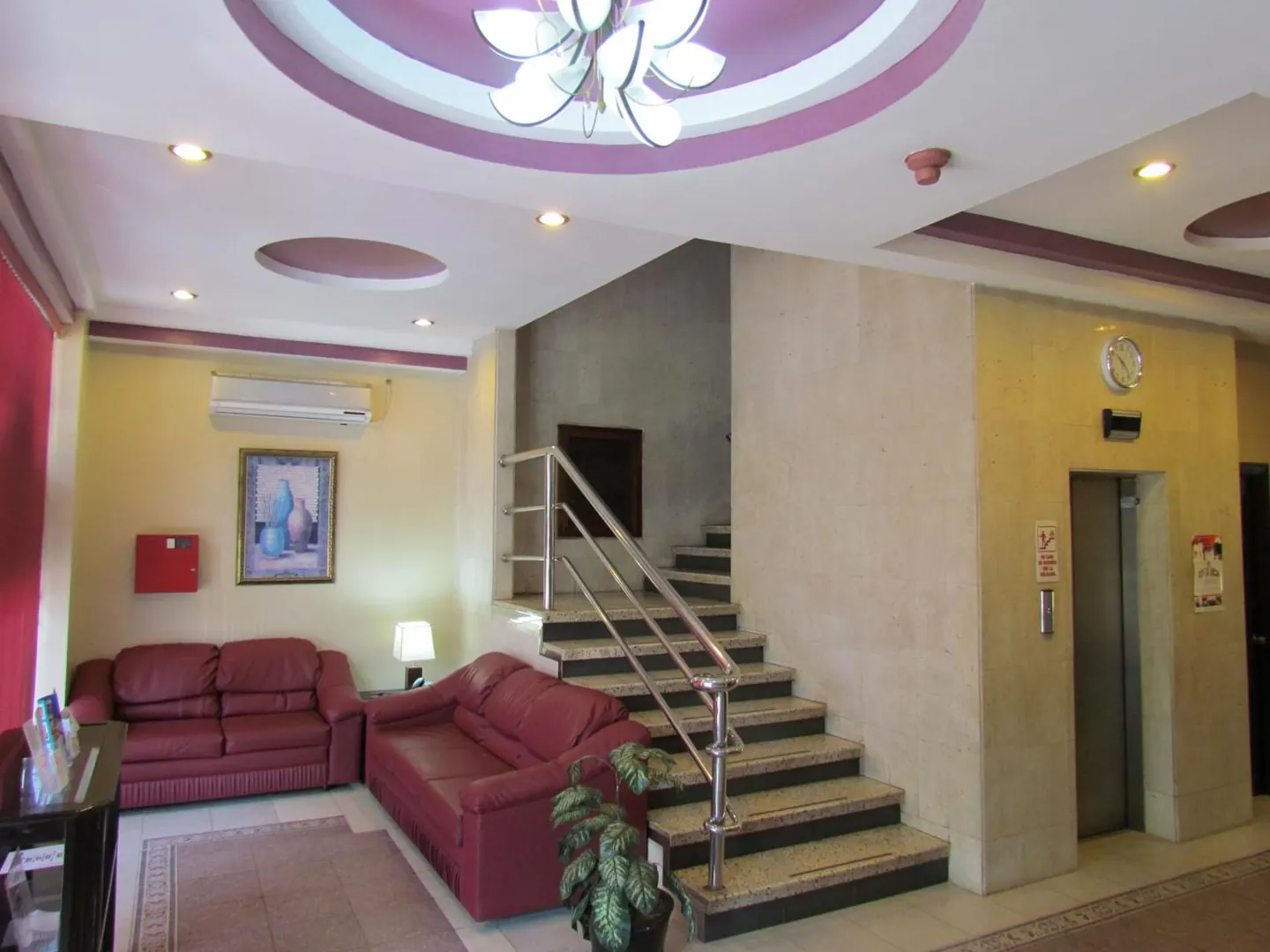 Vestíbulo del Hotel Lisboa con escalera y lámpara central